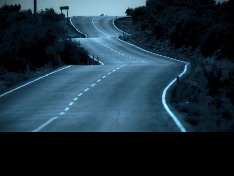 road on a wintry night winding through the hills 