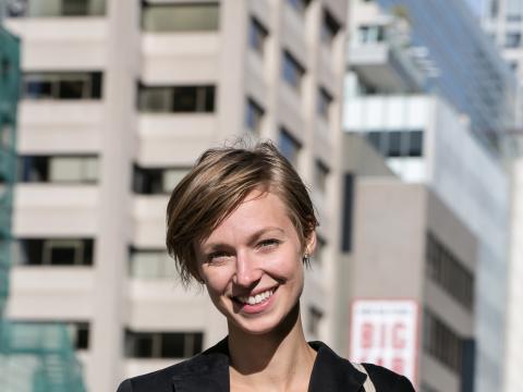 Courtney Reeve in jacket in front of city buildings