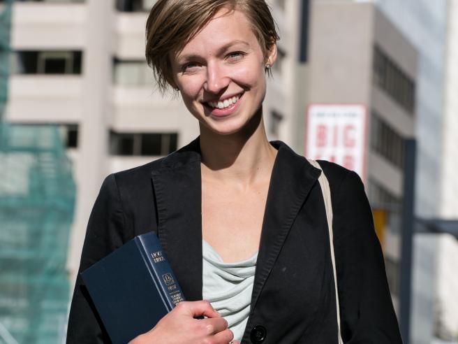 Courtney Reeve in jacket in front of city buildings