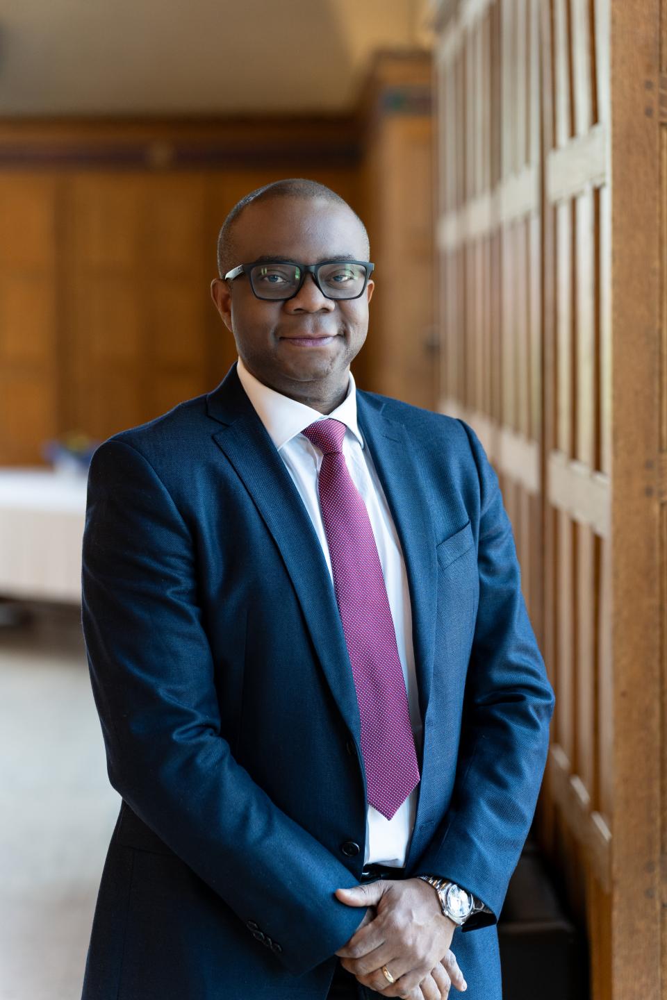 Dr Victor Ezigbo in Great Hall against wood panelling (2025)